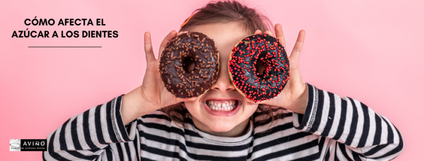 Niña con dos donuts de chocolate, lo cual provoca caries infantil