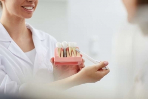 Dentista mostrando los implantes dentales a paciente